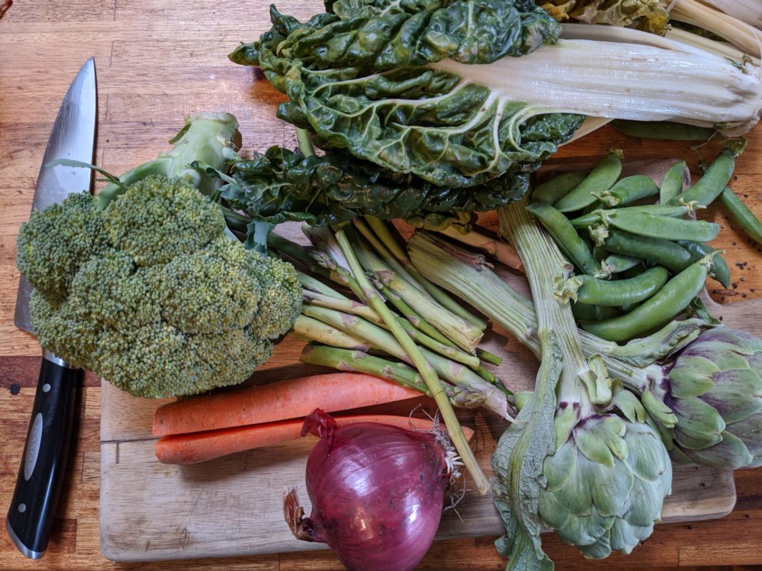 Spring vegetables: carrot, broccoli, silverbeet, red onion, asparagus, peas, artichokes